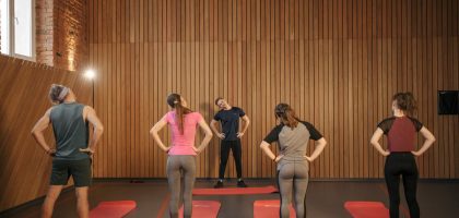 Men and women performing stretching exercises on mats in a fitness class